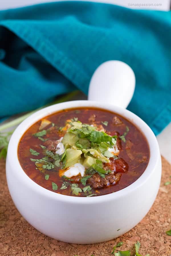 Homemade slow cooker beef chili served with black and red kidney beans topped with avocado and plain greek yogurt.