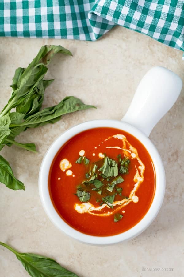 Fresh basil around tomato soup.