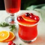 Glass of homemade cranberry juice with fresh orange.