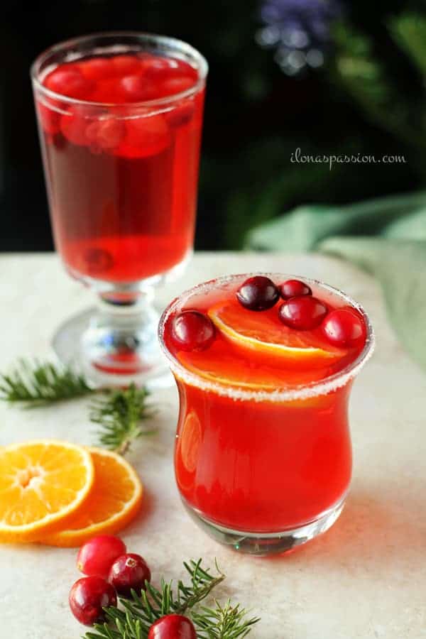 Cranberries in a glass of homemade drink and few slices of orange.