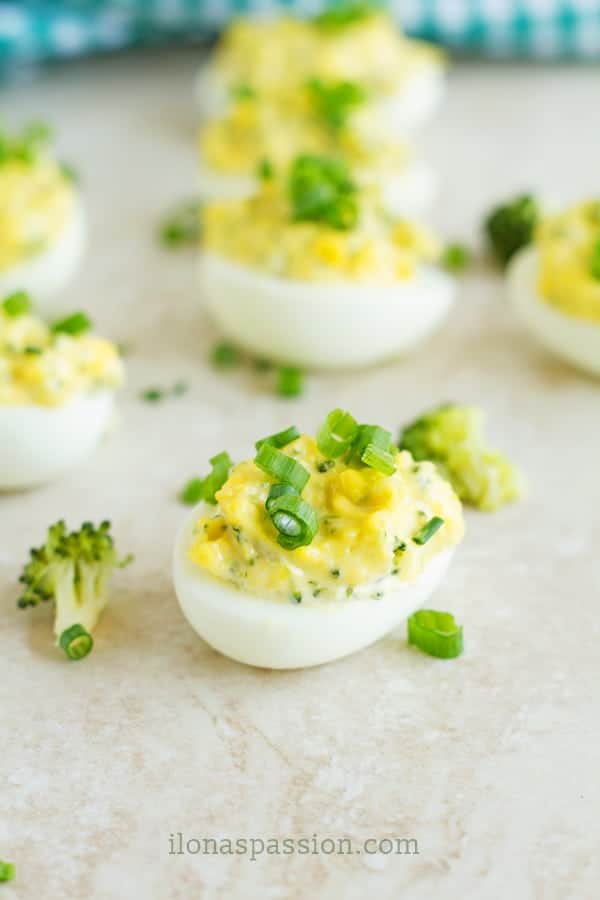 Easy deviled eggs with broccoli florets, dijon and mayonnaise topped with green onion.