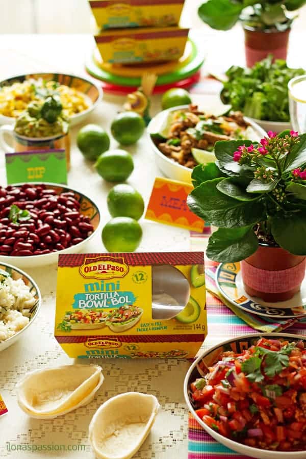 A table set up for a Mexican buffet ideas for party with tortilla bowls with homemade tomato salsa, beans.