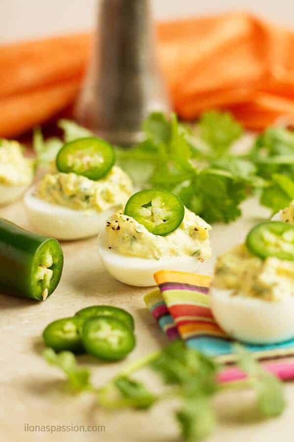 Spicy cut in half egg filled with with cilantro, mayonnaise and jalapeno.