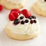 Delicate and elegant triple berry mini pavlovas recipe with whipped cream and raspberries, blueberries and strawberries. Perfect for any occasion! by ilonaspassion.com I @ilonaspassion