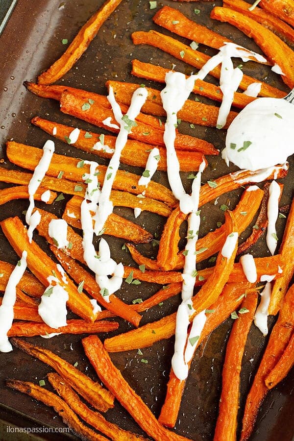 A close up phopto of cut lenghtwise carrot french fries and served with lemon dip.
