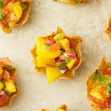 Mango salsa served in mini cups made from corn chips.