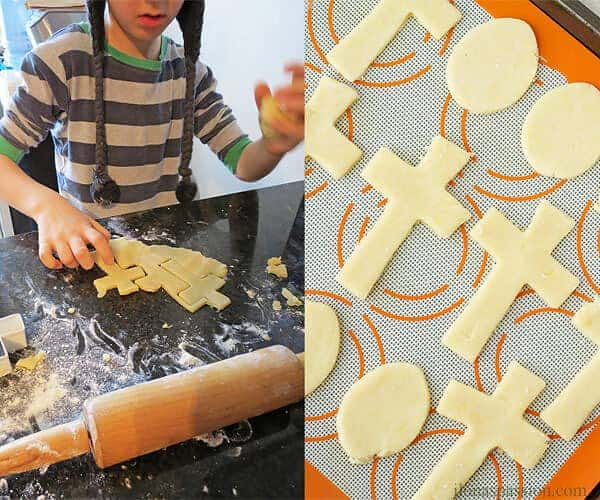 A boy makeing cross sugar cookies on the left and ready to be backed cut out Easter cookies on the right.