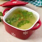 A clear savory meaty liquid with parsley.