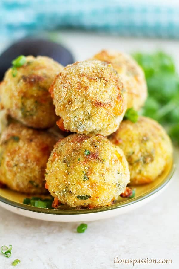 Stuck of arancini placed on a plate topped with green onion.