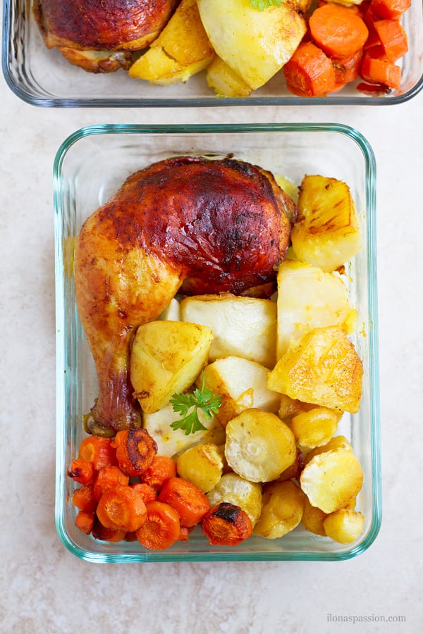 Sheet pan baked chicken legs in oven with carrots, parsnips, potatoes.