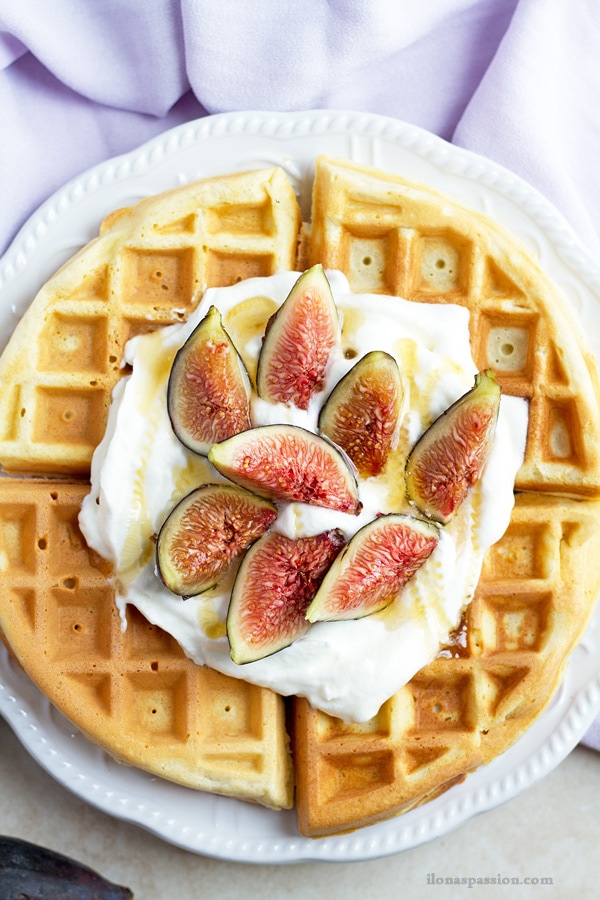 Cooked waffles with fresh figs, whipped cream and honey.