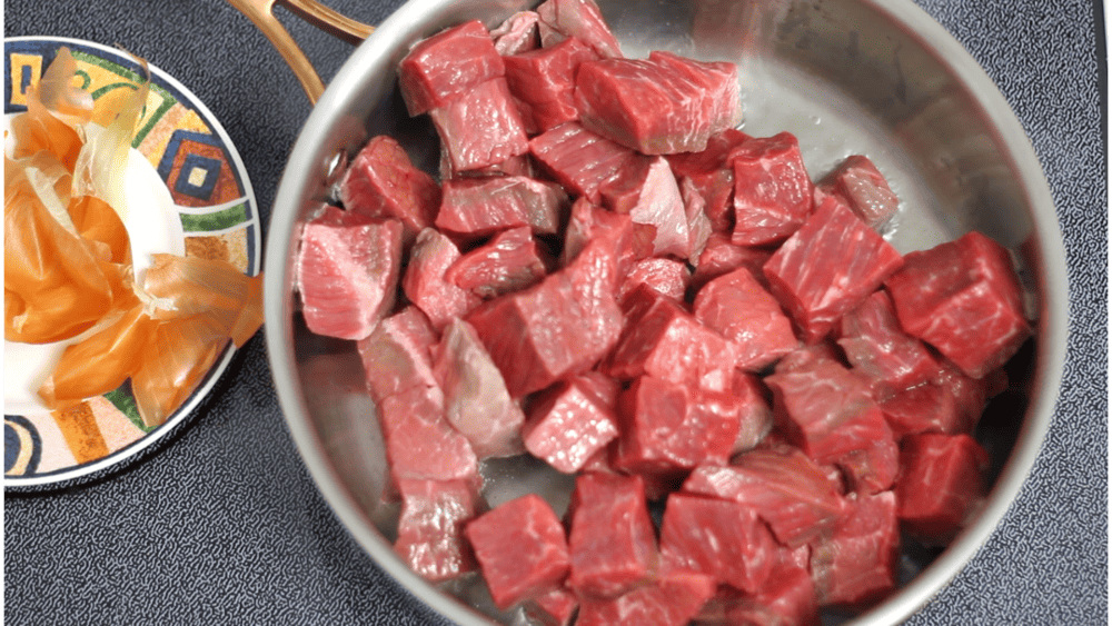 Raw cubed beef in the pot.
