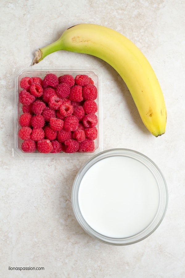 Raspberries, banana, milk in a bowl.