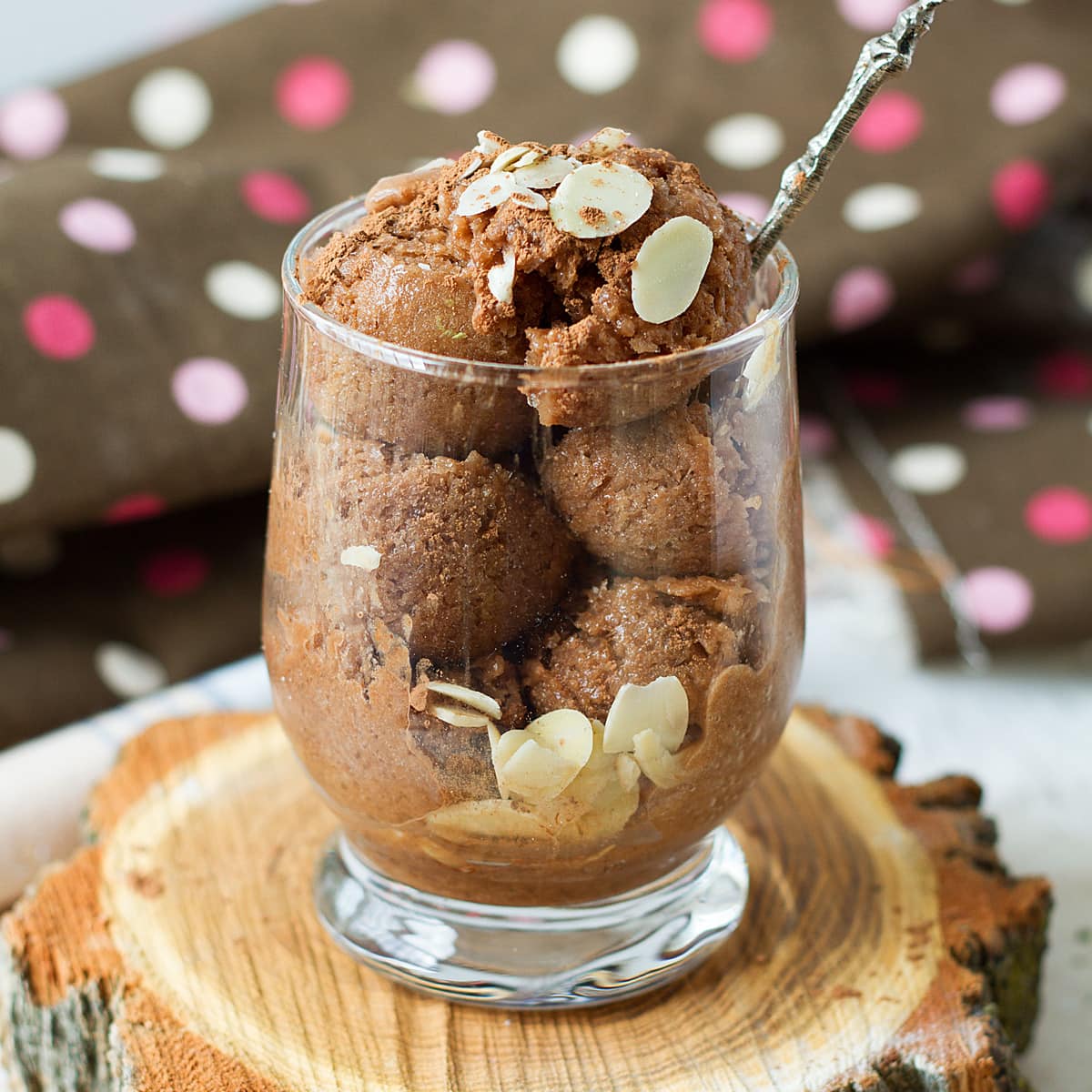 Almond milk chocolate banana ice cream in a cup with sliced almonds.