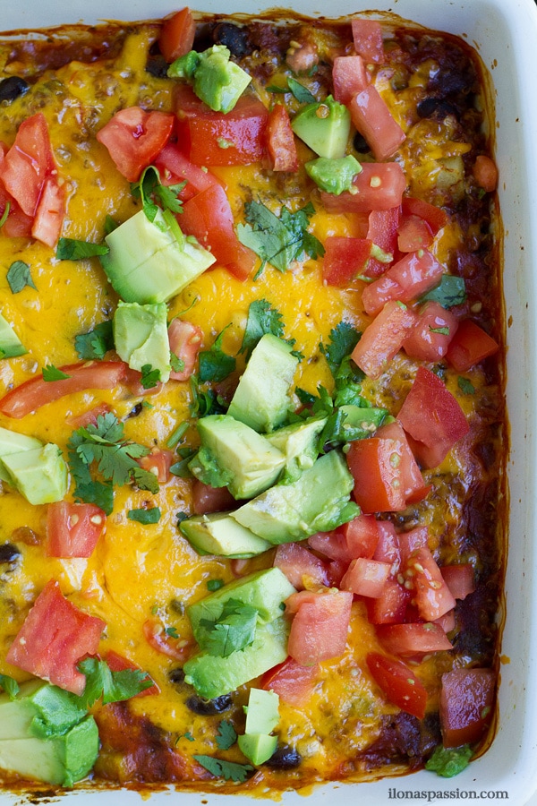 Photo of baked Mexican casserole with fresh tomato and avocado.