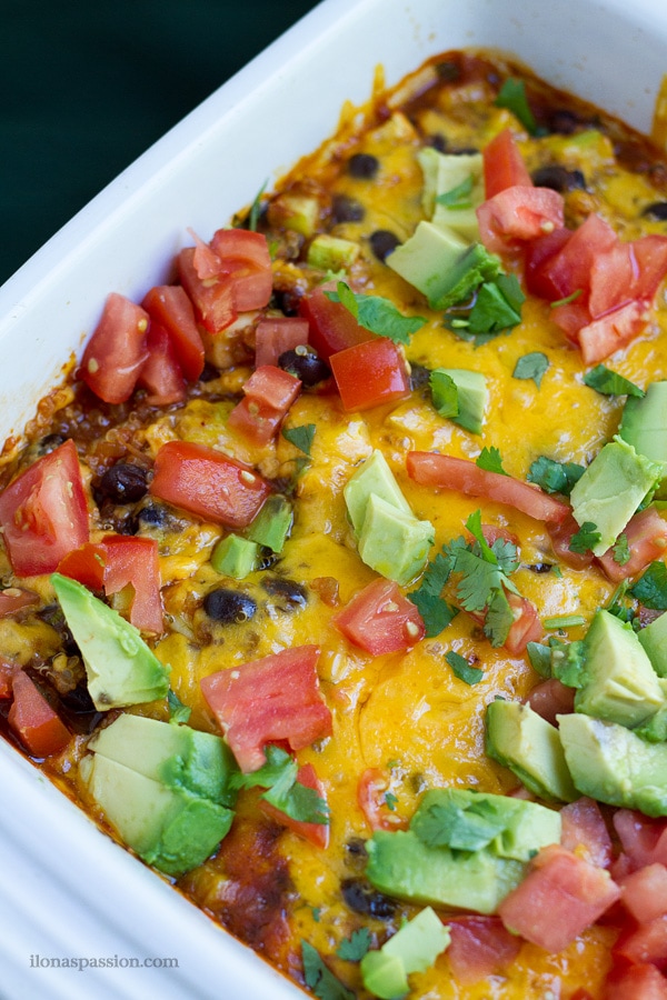 Baked casserole with quinoa, cheddar cheese, black beans, fresh avocado on top.
