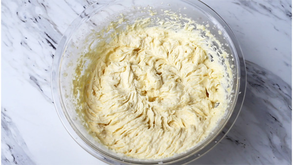 Whipped butter with sugar and egg in a bowl.