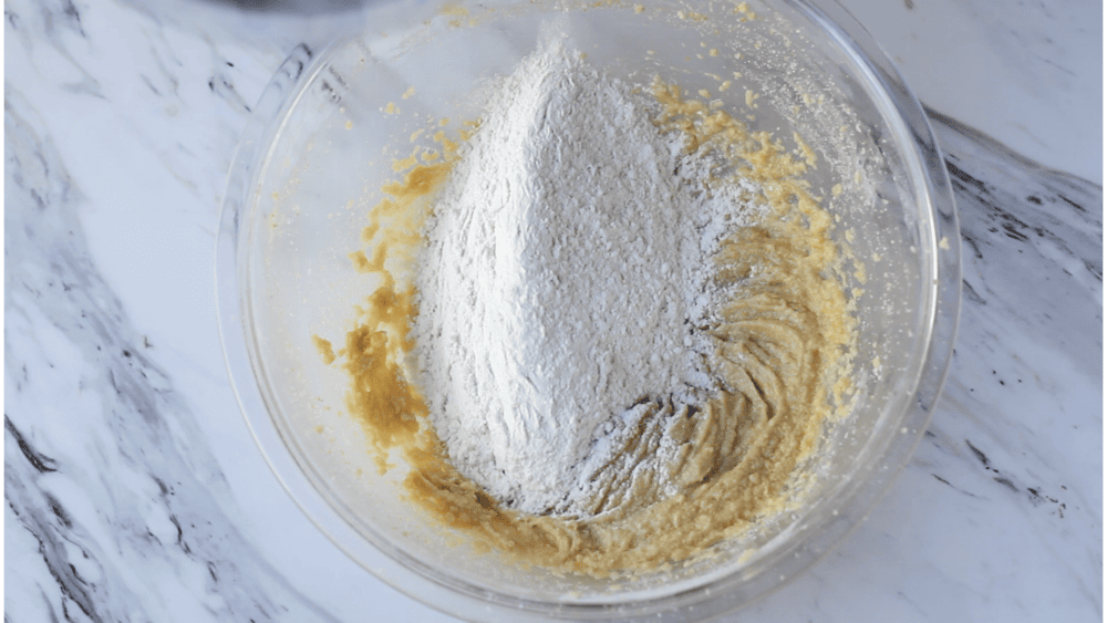 Adding flour to the batter.
