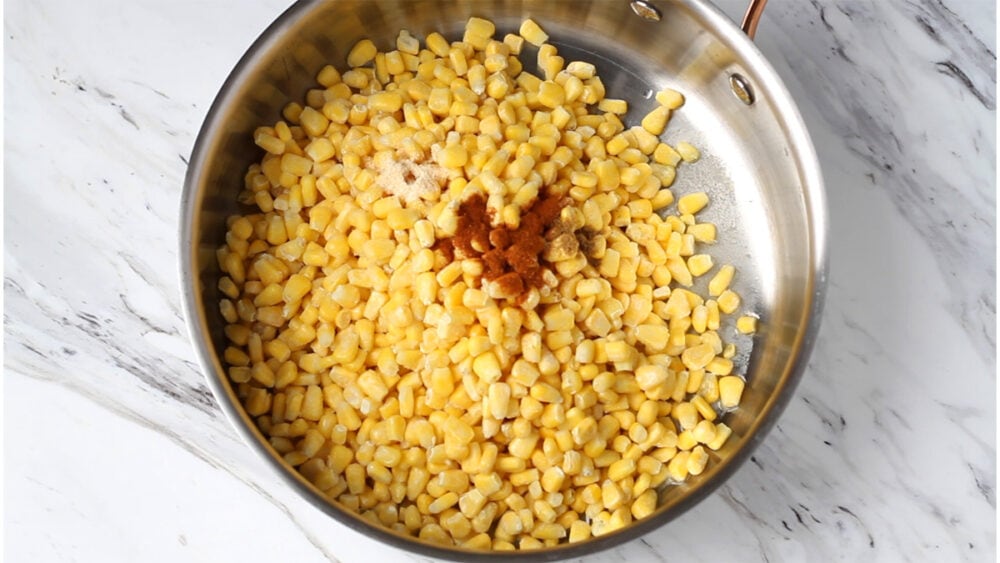 Uncooked corn with sweet paprika in a pot.
